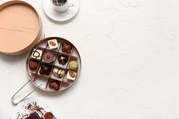 Box with chocolate candies on light background