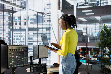Machine learning infrastructure technician using laptop to develop algorithms that enable machines...