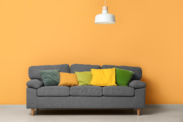 Stylish living room with black sofa, pillows and hanging lamp