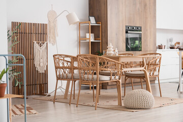 Wicker chairs, table and folding screen in interior of stylish dining room