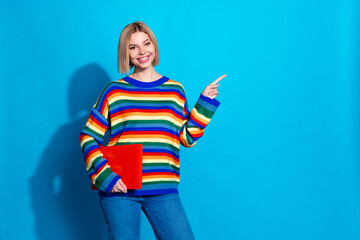 Photo portrait of lovely young lady point empty space netbook dressed stylish striped garment isolated on blue color background