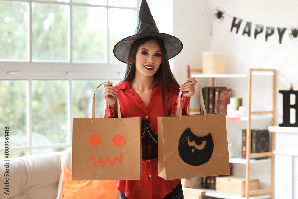 Canvas Prints Beautiful young happy Asian woman dressed as witch for Halloween with shopping bags in decorated living room