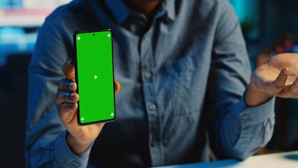 Content creator films chroma key smartphone video review for tech enthusiasts, close up. Viral online star hosts technology internet show, unboxing isolated screen cellphone, focus on product