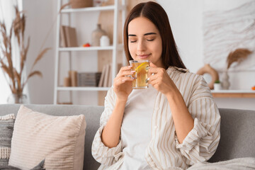 Young woman with cup of green tea sitting at home on autumn day