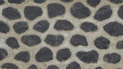 Abstract shapes, patterns and textures of black stone walls arranged neatly. The shape of a round stone arrangement. Highway cliff wall