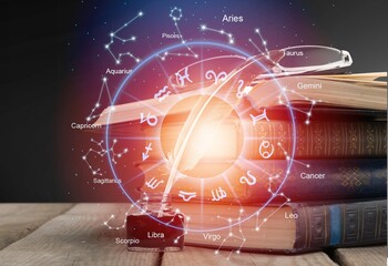 Open book, astrological signs against dark background