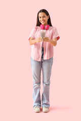 Young woman with chia seed water on pink background