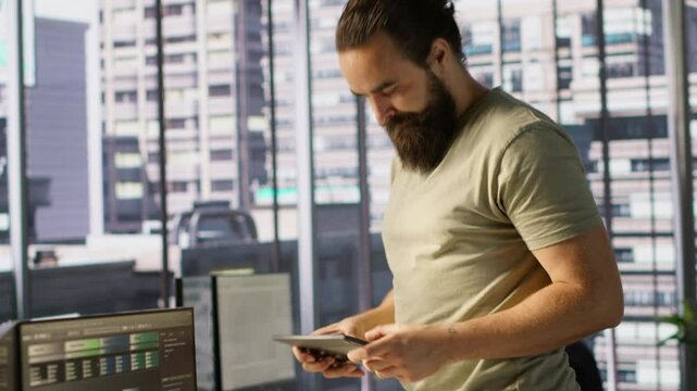 Programmer developing machine learning APIs solving complex problems, checking performance on tablet. Man training predictive models capable of handling resource intensive tasks, camera A