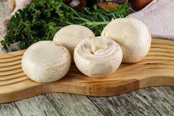 White champignon mushrooms heap over board