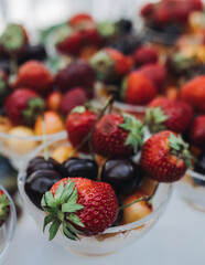 Beautifully decorated banquet catering table, assortment variety of berries with cherry, strawberry, raspberry and apricot, on luxury birthday party event or wedding reception celebration