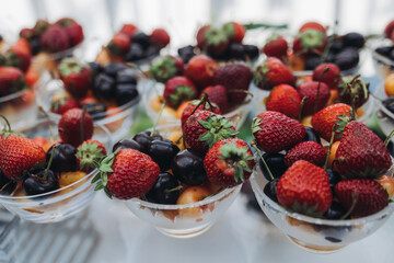 Beautifully decorated banquet catering table, assortment variety of berries with cherry, strawberry, raspberry and apricot, on luxury birthday party event or wedding reception celebration