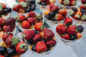 Beautifully decorated banquet catering table, assortment variety of berries with cherry, strawberry, raspberry and apricot, on luxury birthday party event or wedding reception celebration