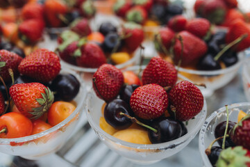 Beautifully decorated banquet catering table, assortment variety of berries with cherry, strawberry, raspberry and apricot, on luxury birthday party event or wedding reception celebration