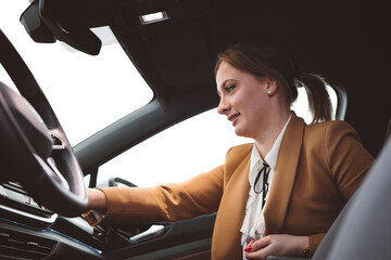 Businesswoman waiting on the sidewalk to be picked up by an electric car driver