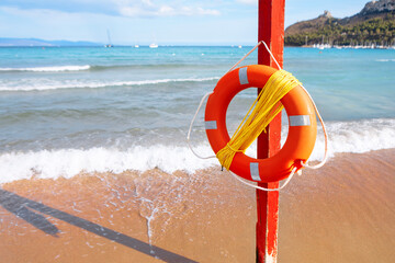 Lifebuoy with rope mounted on a pole on the beach. Life preserver serving as a vital safety measure...