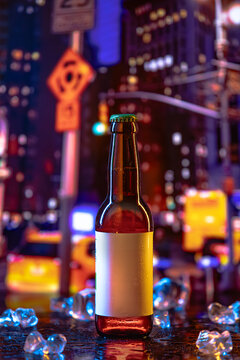Chilled beer bottle is placed on a reflective surface surrounded by ice, with bustling city lights and yellow taxis illuminating the nighttime atmosphere.