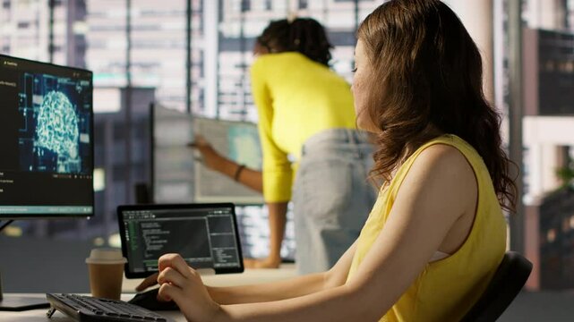Admin tests on computer and tablet to optimize artificial intelligence machine learning models for performance and accuracy. IT worker in office analyzing and interpreting complex AI data, camera A