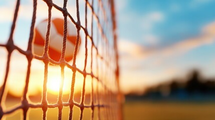 A sports ball caught in a goal net against a stunning sunset, merging athletic achievement with the beauty of nature’s warm, golden glow in perfect harmony.