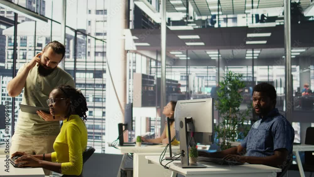 Poster manager coming to check on it employee at office desk testing and deploying programs and systems. te