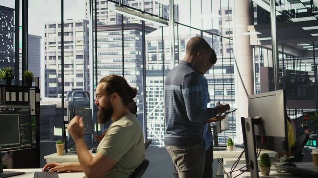 Technician and colleague using device for managing cloud computing platforms training machine learning models. IT staff members in office monitoring company systems using tablet, camera B
