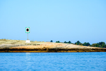 Fototapeta premium aid to navigation on large rock in georgian bay port hand day beacon room for text blue sky background