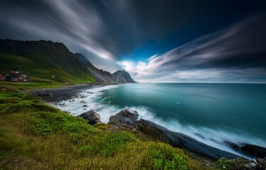 Fototapeta premium Long exposure shot of a mountainous coastline with a dramatic sky and blue ocean.