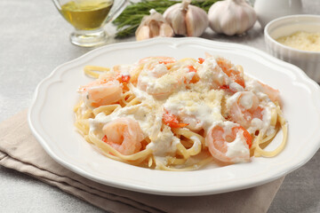 Delicious pasta with shrimps served on light table, closeup