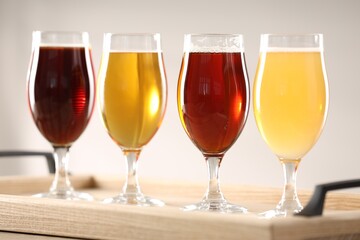 Glasses with different types of beer on table indoors, closeup