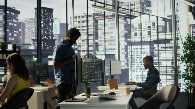 Computer scientist resuming work after strolling in workspace, doing software debugging using PC. Man walking with tablet in office, fixing coding issues using computer, camera B