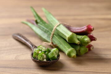 Fresh green and red okra on wooden background, Organic vegetable, Food ingredient