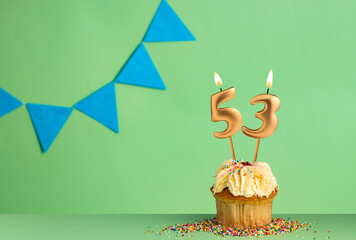 Birthday cupcake with number 53 candle - Green background with blue pennants.