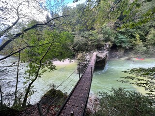 Fototapeta premium Brjeka footbridge, Bovec (Triglav National Park, Slovenia) - Die Fußgängerbrücke Brjeka über die Fluss Soca, Bovec (Triglav-Nationalpark, Slowenien) - Brv Brjeka, Bovec (Triglavski narodni park)