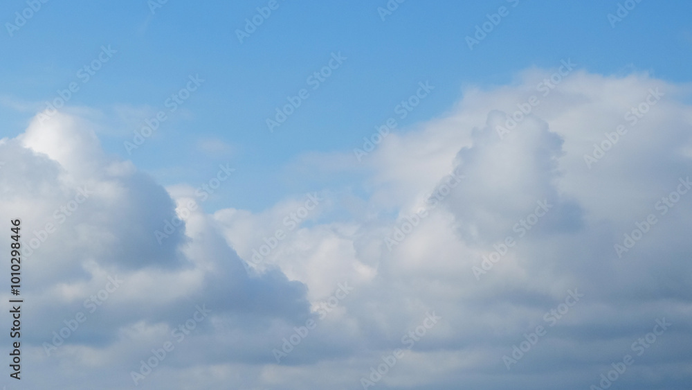 Poster blue sky with dramatic white clouds in abstract shapes, patterns and textures. clumpy clouds in the 