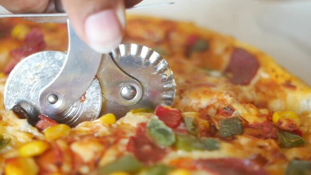 Cutting Fresh Pizza Using a Specialized Pizza Wheel Cutter for Optimum Slicing Results