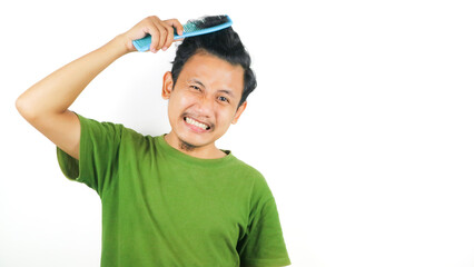 Portrait of Asian man hardly combing his curly hair