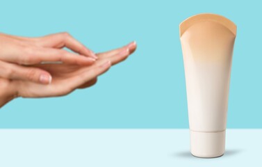 Female hand hold white tube of face cream