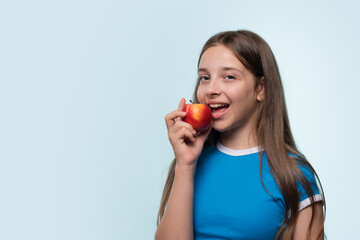 Girl pretending to take bite apple, promoting healthy food choices