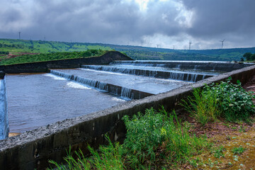 Fototapeta premium Water flows down the Jagmin step dam near Satara India at the end of the monsoons. Monsoon is the annual rainy season in India from June to September.