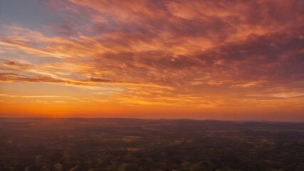 Fototapeta premium A breathtaking golden hour sky with a warm, golden glow, streaks of orange and pink clouds scattered across the horizon as the sun sets 