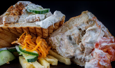 Cut doner with a crispy crust and delicious meat and vegetable filling on a dark background.