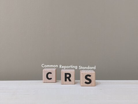 CRS letters on wooden cube stands for Common Reporting Standard. business finance , industrial