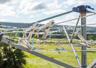 Wet weather concept image with clothes pegs on a washing line dripping wet. Laundry and drying concept. No tumble drier and wet clothes. 
Difficulty in drying clothes. English weather.