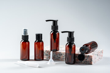 Elegant amber glass bottles displayed on a textured stone surface in a minimalist studio setting