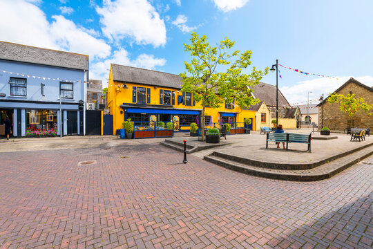 Market Quay, a small market square full of brightly painted cafes and shops near the port and marina of the seaside village of Kinsale, Ireland.