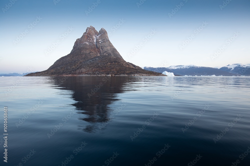 Wall mural big icebergs in atlantic ocean, icefjord in western greenland. blue sea and the blue sky at sunset. 