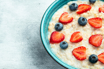 Homemade breakfast . Oatmeal with milk and berries . Top view
