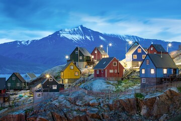 Baffin Bay, colorful typical houses in small village Uummannaq, Greenland Icefjord in Greenland and the silhouetted hight mountain ridge in the background under a blue
Melting icebergs by the coast of