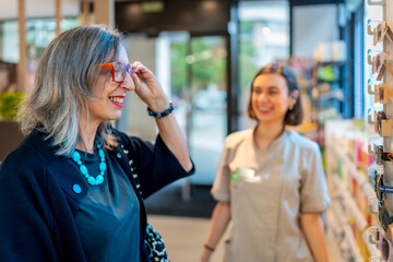 Mature woman trying on glasses in the optical store