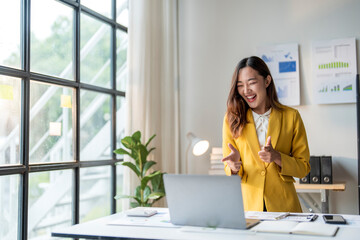 Asian businesswoman pointing at laptop screen having video call at office