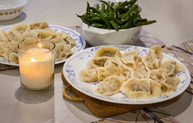 Freshly cooked homemade dumplings and candles on the table.